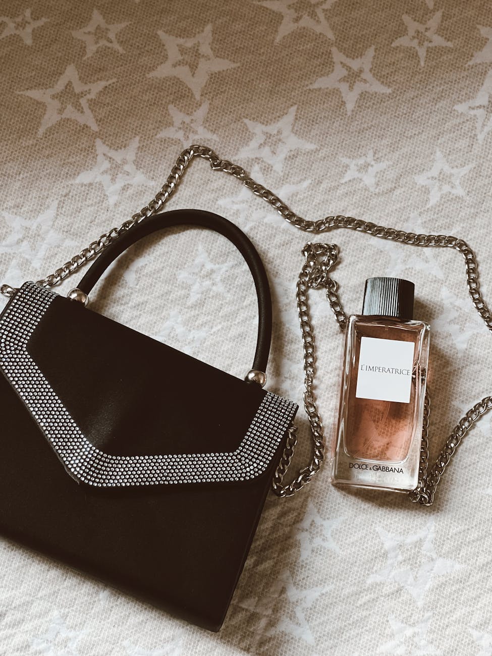 chic handbag and perfume on starry background